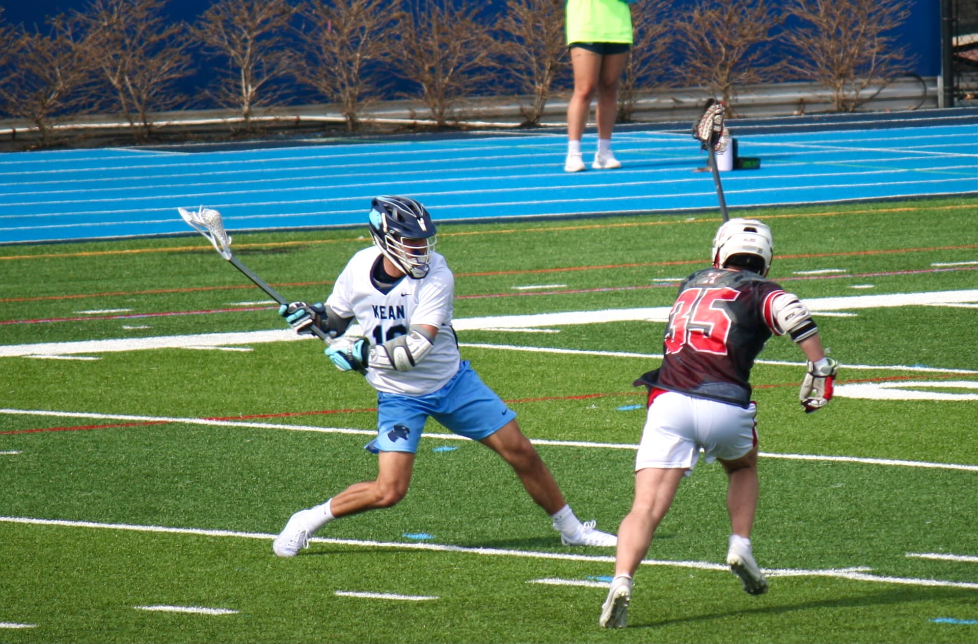 A screenshot of a video call. The coach says “Let’s review your throw”, and is sharing an image of the player wearing lacrosse equipment. The player has just thrown the ball, and the image is digitally marked up to show the elbow location and arm angle.